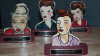 Four painted statuettes that are designed to look like different women