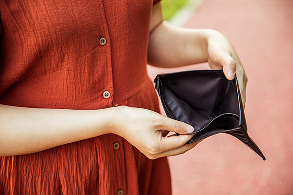 Woman looking in empty wallet