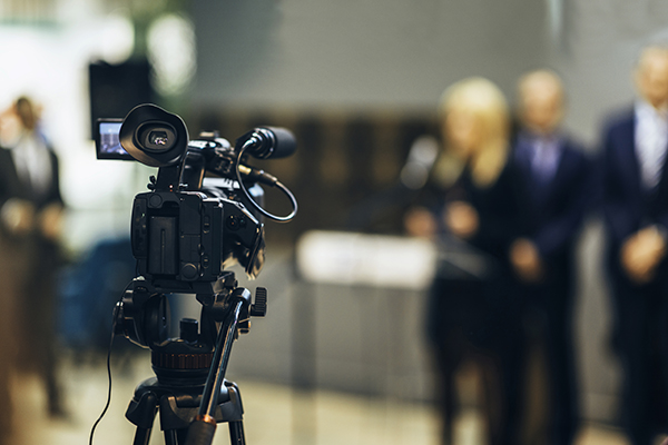 People gathered in front of a news camera