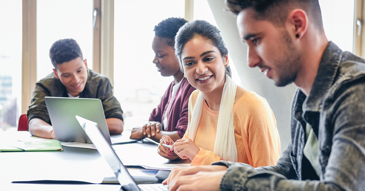 A group of young people working on laptops