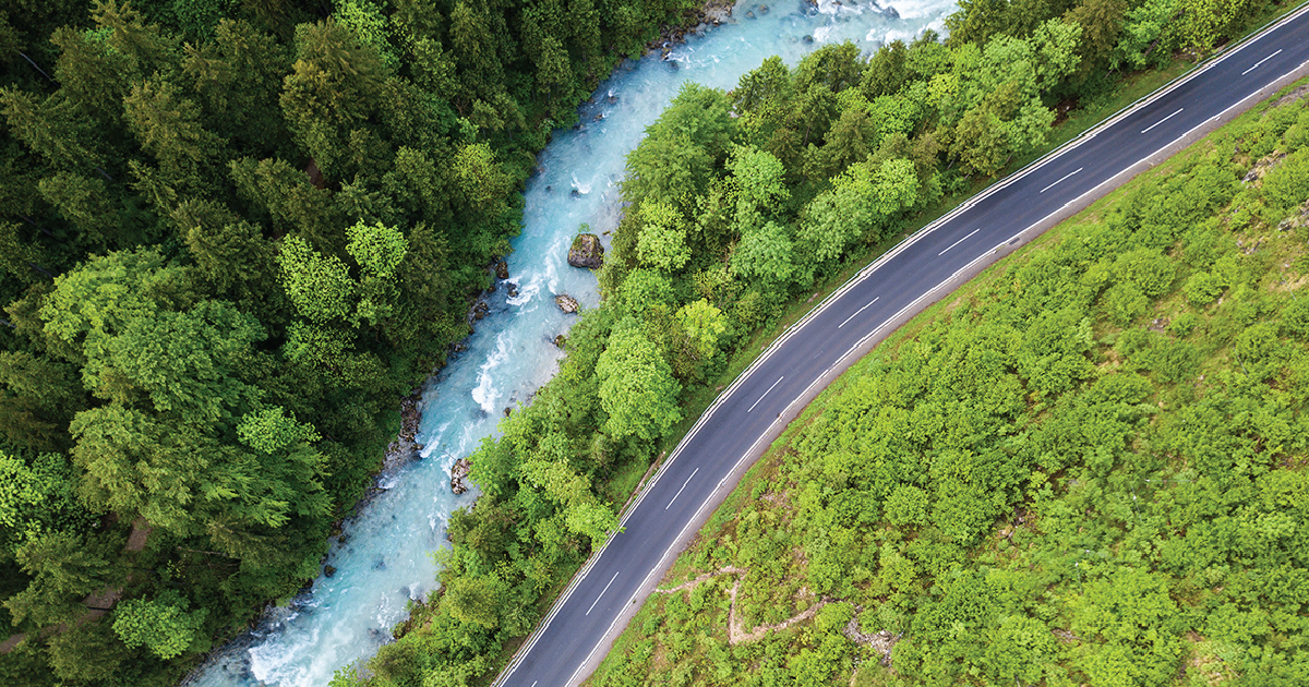 Aerial shot of a winding river next to a road