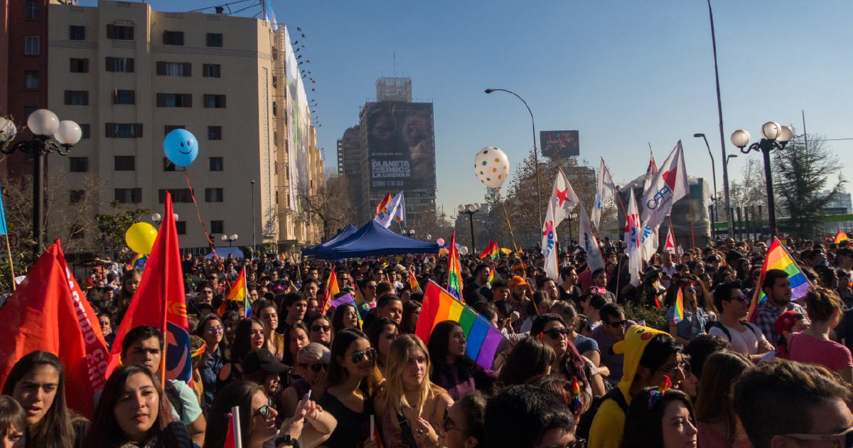 Crowd of people holding rainbow flags in Chile