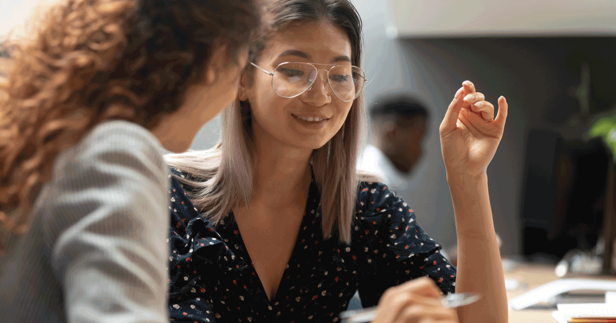 Two women talking and looking over papers together