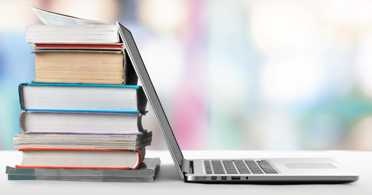 A stack of books next to a laptop