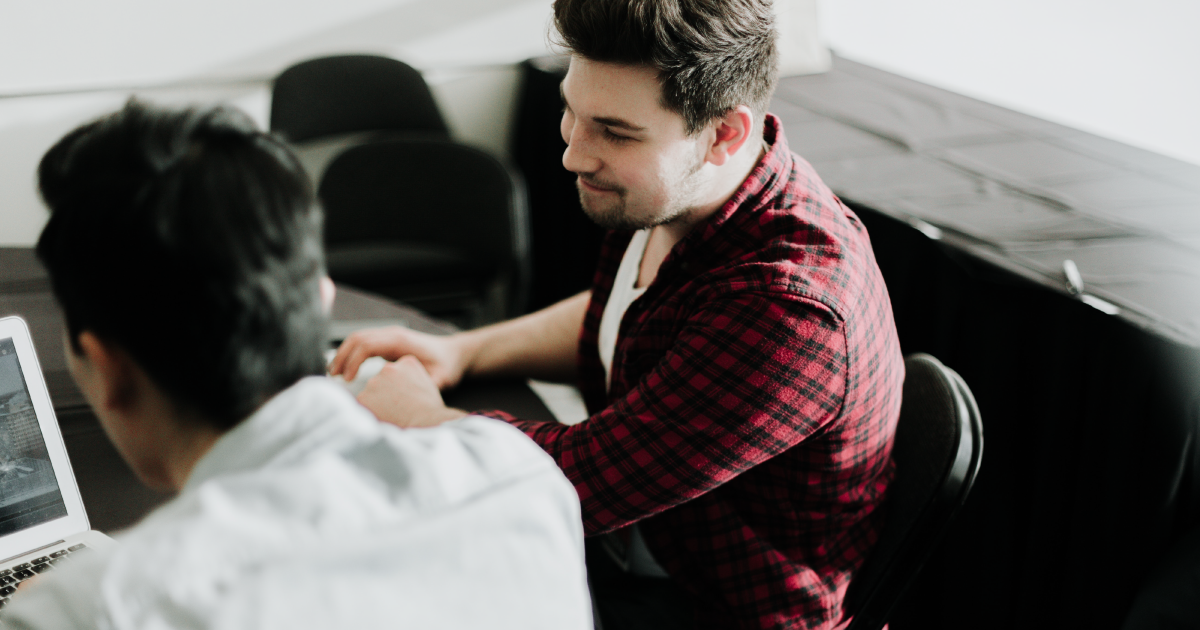 Two men working at a laptop