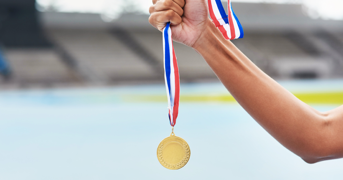 Person holding up a gold medal