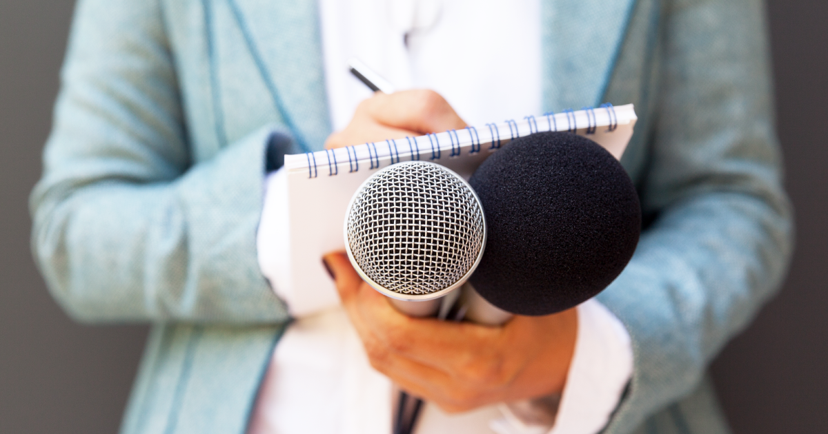 Reporter holding a notebook and microphones