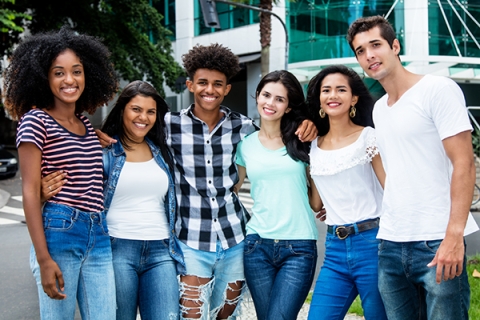 Group of young people with their arms around each other