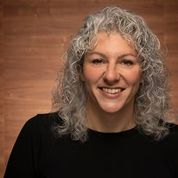 White woman with grey curly hair