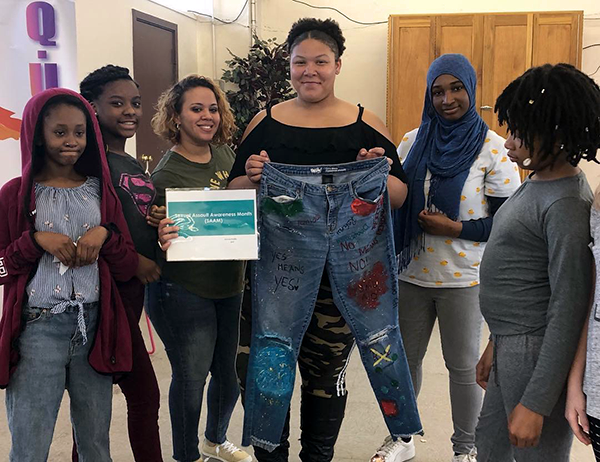 Group holding up jeans
