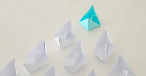 Teal paper boat leading the way