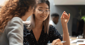 Two women talking and looking over papers together