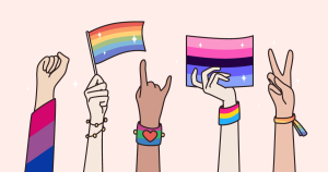 Many hands wearing rainbow bracelets and sleeves are uplifted in empowerment, the first makes a fist, the second holds a rainbow pride flag, the third  makes a 'hang loose' sign with the hand, the third holds the bisexual flag, the last makes a peace sign.