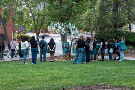 Students gathered around a tree during a Take Back The Night display