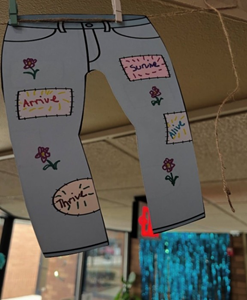 Pair of jeans on display on a clothesline with affirming messages